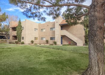 The exterior of a building with a green lawn and trees