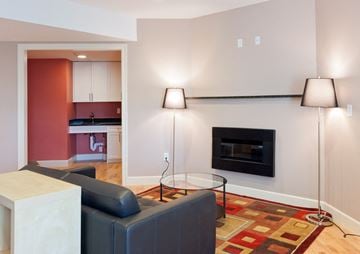Cambridge apartment for rent - a living room with a black couch and a fireplace