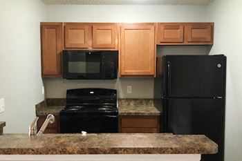 Kitchen with white cabinetry and black appliances