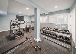 Albany apartment for rent - A home gym with a treadmill, elliptical machines, and dumbbells.