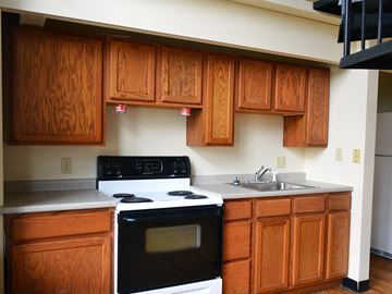 Worcester apartment for rent - a kitchen with wooden cabinets and a stove and a sink