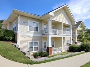 Durham apartment for rent - a yellow house with a porch and a sidewalk in front of it