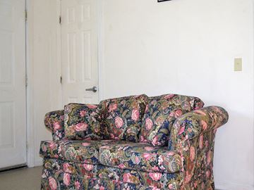 New Haven apartment for rent - a floral couch in a living room with a white door