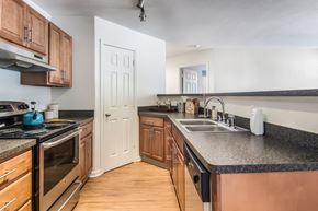 Akron apartment for rent - A kitchen with wooden cabinets and black countertops.