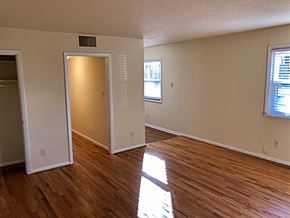 Raleigh apartment for rent - an empty living room with wooden floors and a door to a closet
