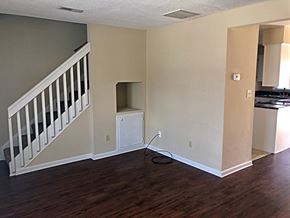 Greenville townhouse for rent - A room with a staircase on the left and a kitchen area on the right.