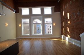 La Crosse apartment for rent - an empty living room with large windows and wood floors