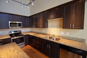 La Crosse apartment for rent - a kitchen with granite counter tops and dark wood cabinets