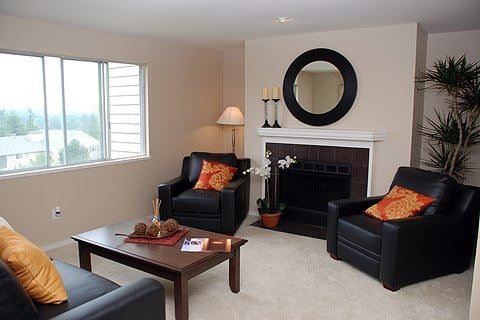 Federal Way apartment for rent - A living room with two black leather chairs and a fireplace.