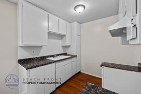 Long Beach apartment for rent - a kitchen with white cabinets and granite counter tops and a sink