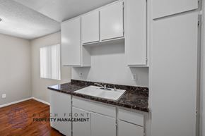Long Beach apartment for rent - a kitchen with white cabinets and a sink and a counter top