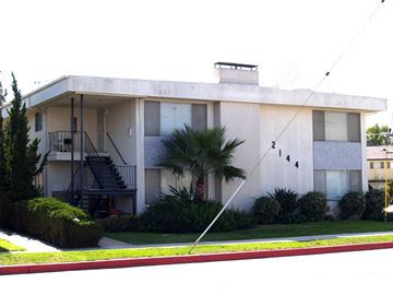 Torrance apartment for rent - a white building with a palm tree in front of it
