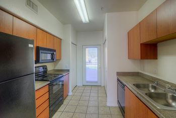 A kitchen with black appliances and wooden cabinets