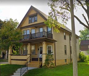 Milwaukee triplex for rent - A two-story house with a balcony on the second floor.