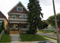 Milwaukee triplex for rent - A house with a red roof and a porch.