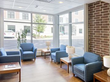 West Roxbury apartment for rent - a living room with blue chairs and a brick wall