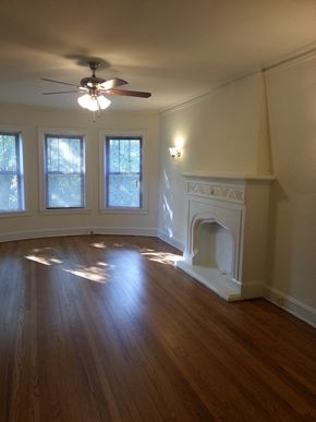 Evanston apartment for rent - an empty living room with a fireplace and a ceiling fan