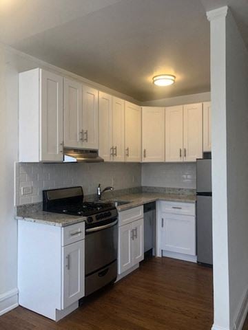 Evanston apartment for rent - a kitchen with white cabinets and a stove and refrigerator