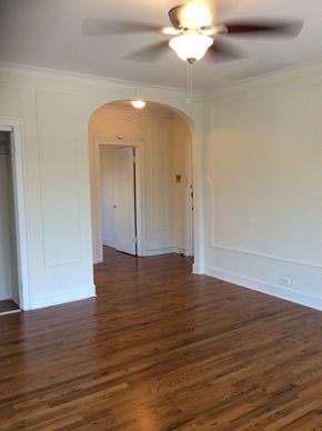Evanston apartment for rent - an empty living room with white walls and a ceiling fan
