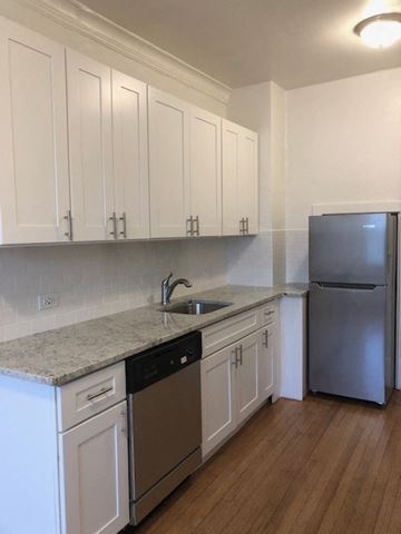 Evanston apartment for rent - a kitchen with white cabinets and a sink and a refrigerator