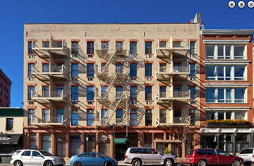 New York apartment for rent - a large brick building with cars parked in front of it