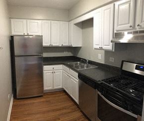 Glen Ellyn apartment for rent - a kitchen with white cabinets and a stainless steel refrigerator