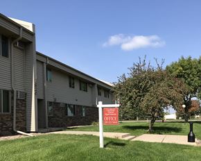 Willmar And  Alexandria apartment for rent - an apartment building with a red and white sign in the grass