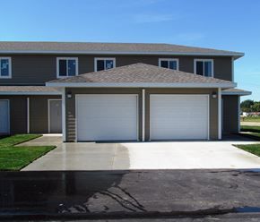 Owatonna townhouse for rent - A house with a grey roof and white garage doors.