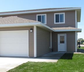 Owatonna townhouse for rent - A house with a brown roof and a white garage door.