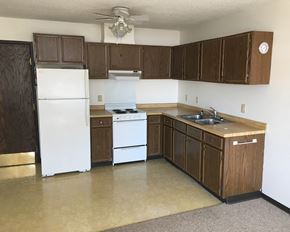 Harmony apartment for rent - an empty kitchen with white appliances and wooden cabinets