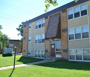 Mankato apartment for rent - a brick building with a green lawn in front of it