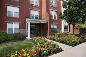 Pittsburgh triplex for rent - the front of a brick office building with flowers in front