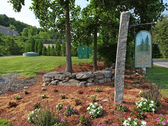 Stow townhouse for rent - a park with a sign and flowers and trees