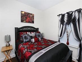 Philadelphia apartment for rent - a bedroom with a bed and curtains and a painting on the wall