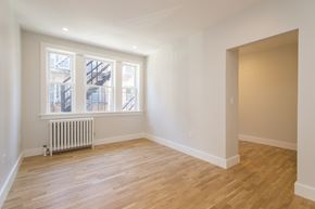 Somerville apartment for rent - a living room with white walls and a window and wooden floors