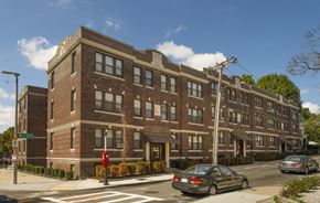 Brighton apartment for rent - a brick apartment building on a city street with cars