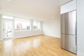 Cambridge apartment for rent - an empty living room with a stainless steel refrigerator