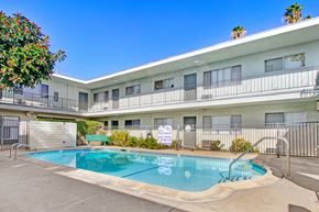 Canoga Park apartment for rent - A pool in front of a white building with balconies.