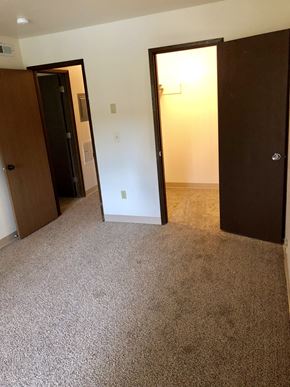 Anchorage apartment for rent - an empty bedroom with three doors and a carpeted floor