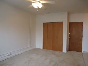 Chicago apartment for rent - an empty living room with a ceiling fan and a closet