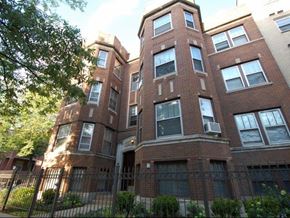 Chicago apartment for rent - a tall brick building with a fence in front of it