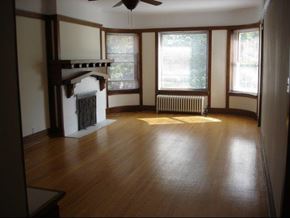 Chicago apartment for rent - an empty living room with a fireplace and wood floors