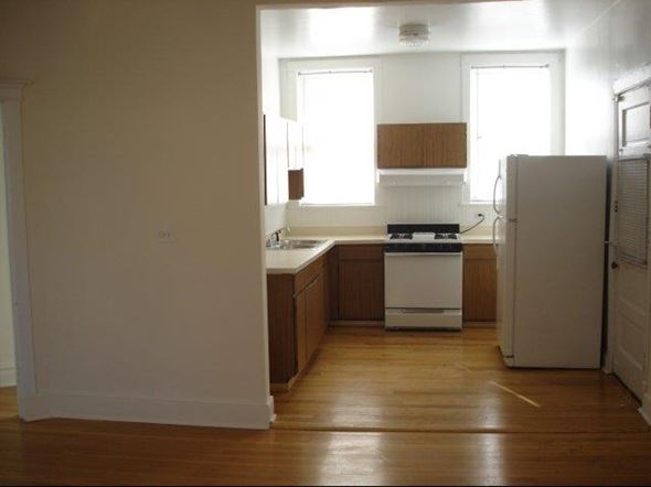 Chicago apartment for rent - an empty kitchen with a stove and a refrigerator