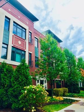 Chicago apartment for rent - a red brick building with trees and bushes in front of it