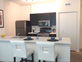 Chicago apartment for rent - a kitchen with a bar and white chairs