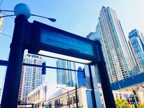 Chicago apartment for rent - a subway sign with skyscrapers in the background