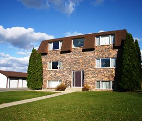 North Mankato apartment for rent - a brick house with windows and a green lawn