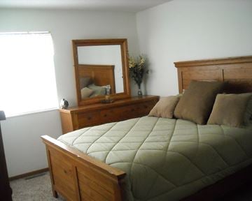 Luverne townhouse for rent - a bedroom with a bed and a dresser with a mirror