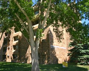 Pipestone apartment for rent - a brick building with a tree in front of it