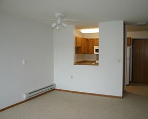 Albert Lea townhouse for rent - an empty living room with a ceiling fan and a kitchen